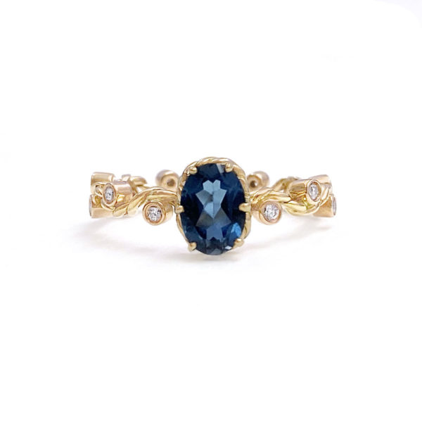 London-blue-topaz Solitaire with JeweLyrie Signature twist wave shank with diamondsin 14k and 18k made to order by JeweLyrie