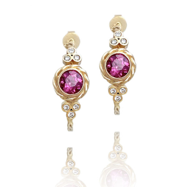 Lined twist earrings showcasing bezel set rhodolite garnet wrapped with signature twist and flanked with diamond trio clusters by JeweLyrie